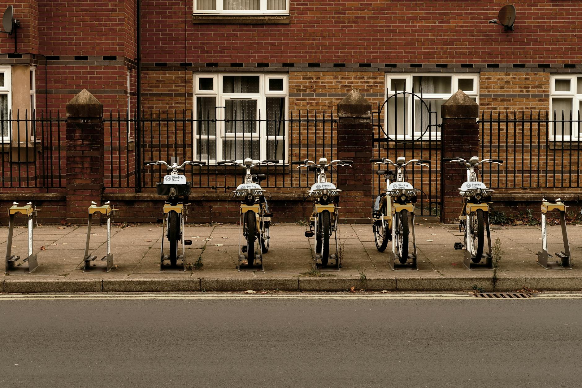 Rząd miejskich rowerów pod ceglaną ścianą budynku
