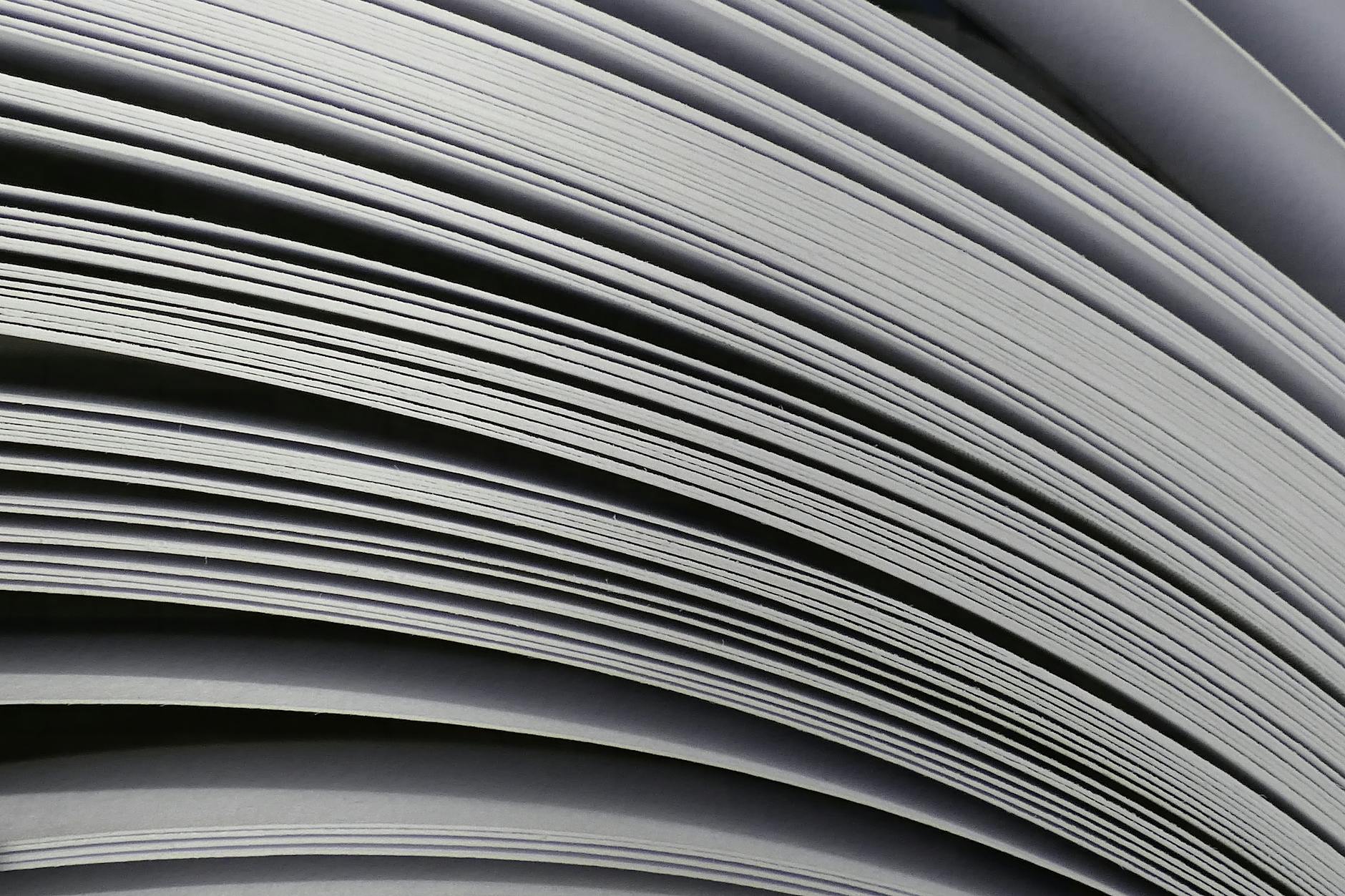 Zbliżenie na zakrzywione warstwy ułożonych arkuszy papieru