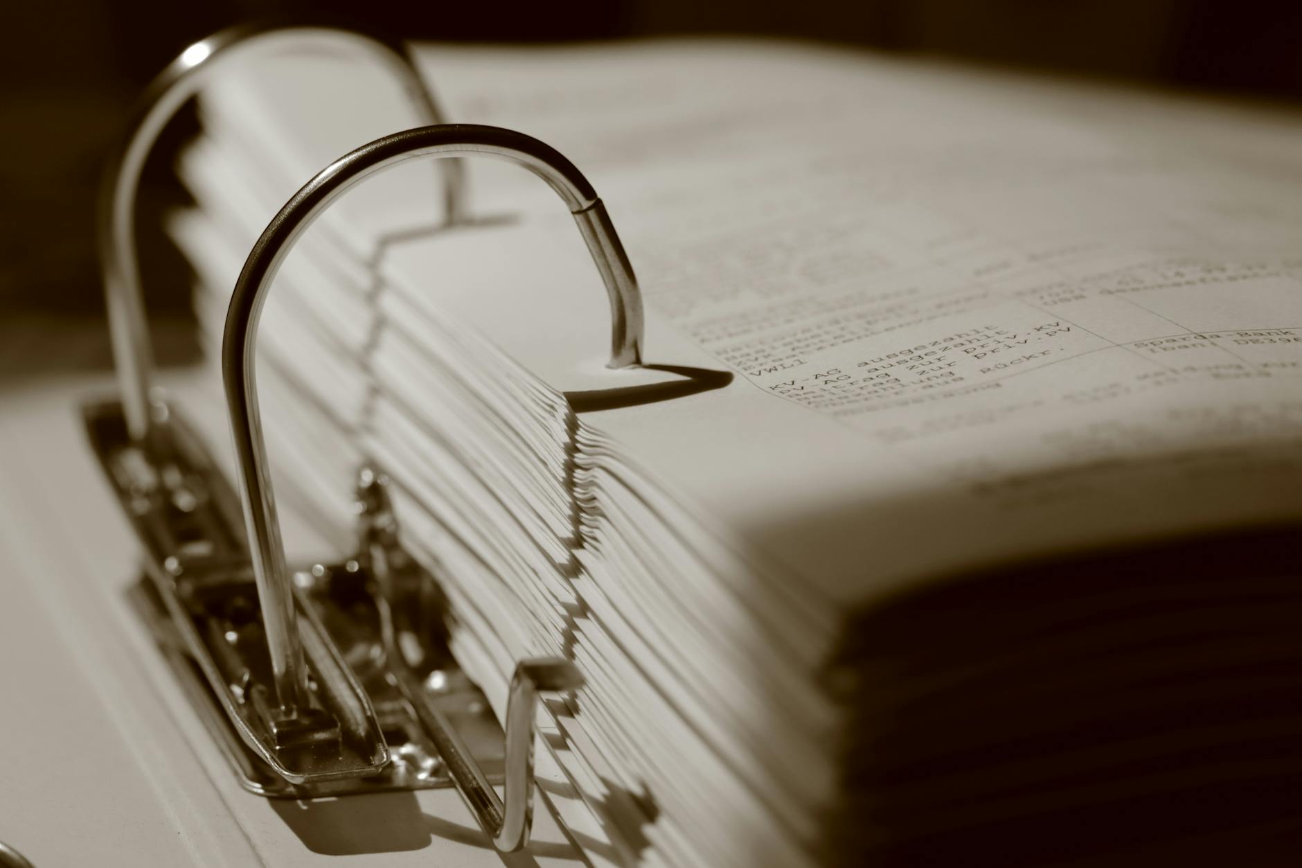 Zbliżenie segregatora wypełnionego dokumentami w sepii