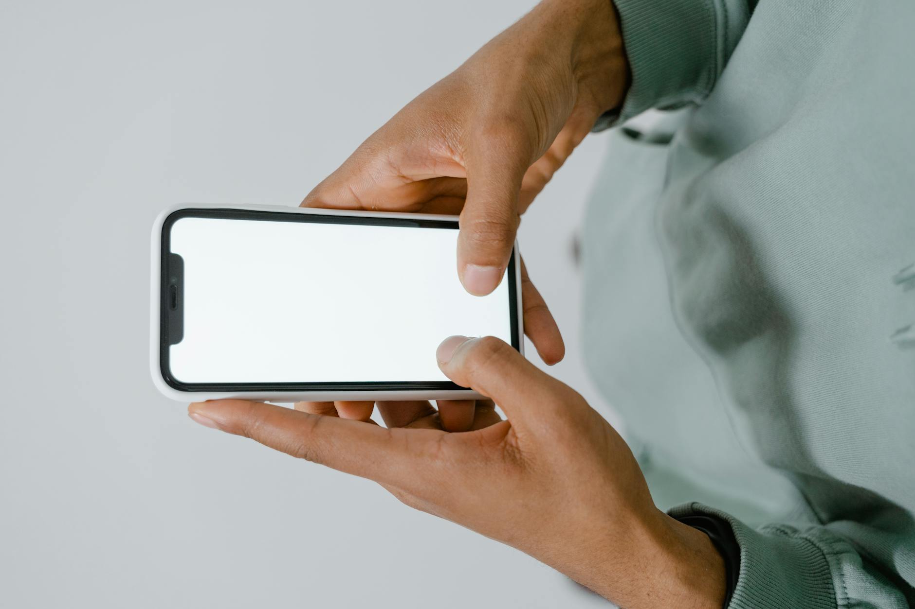 Dłonie trzymają smartfon z pustym ekranem na potrzeby projektu BIP