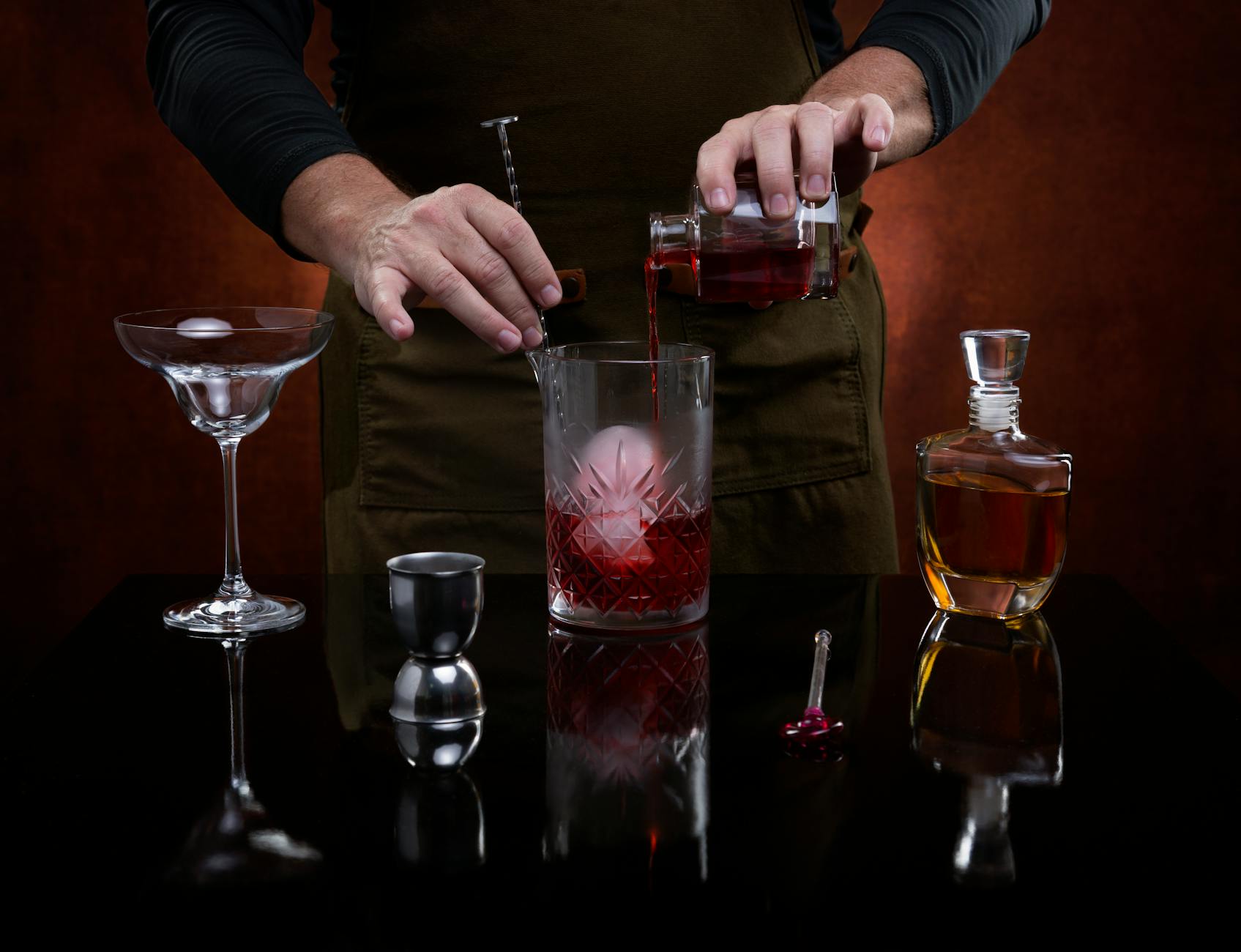 Barman przygotowuje klasycznego drinka za ladą eleganckiego baru