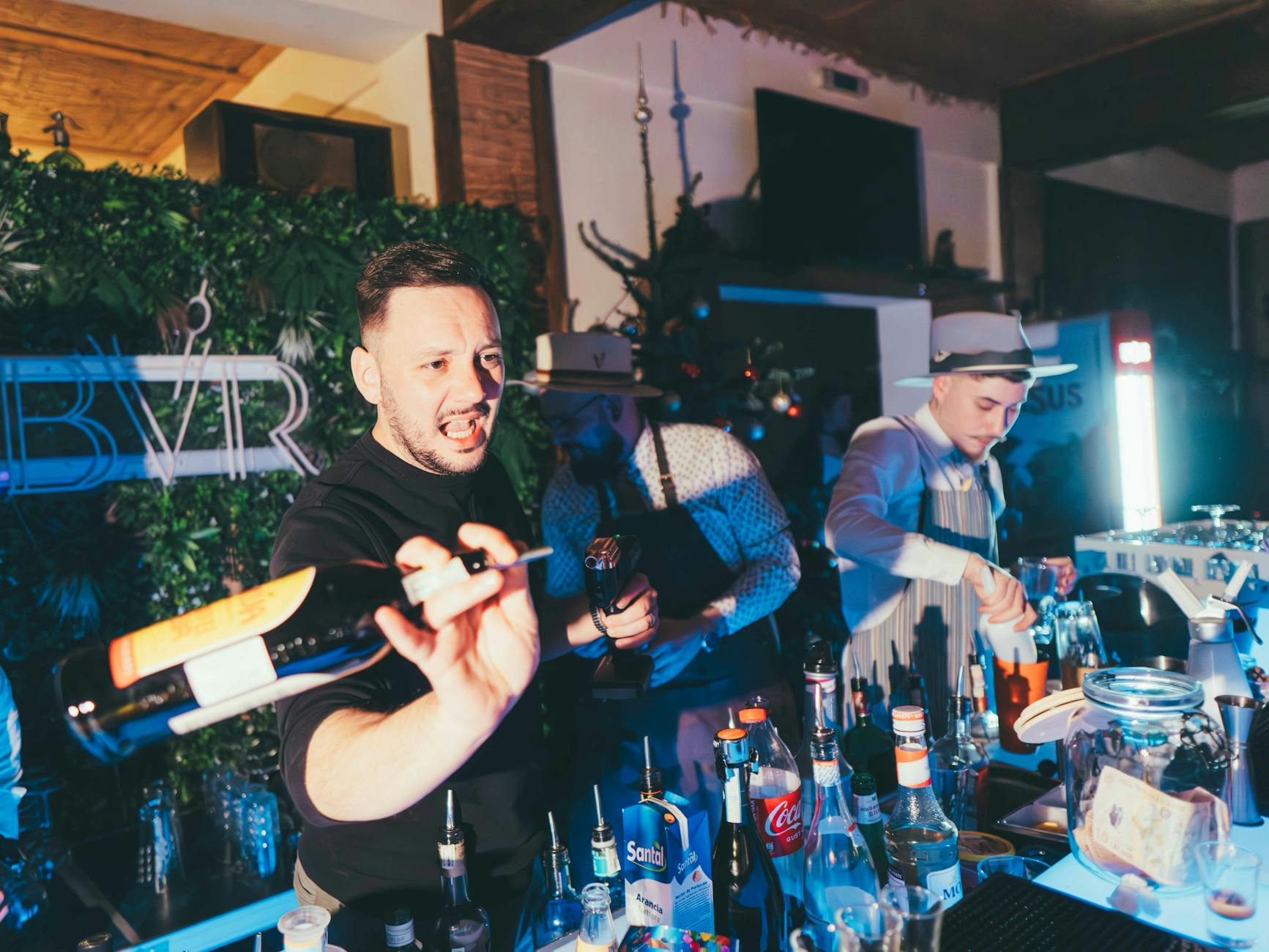 Barmani przygotowują kolorowe drinki w tętniącym życiem barze