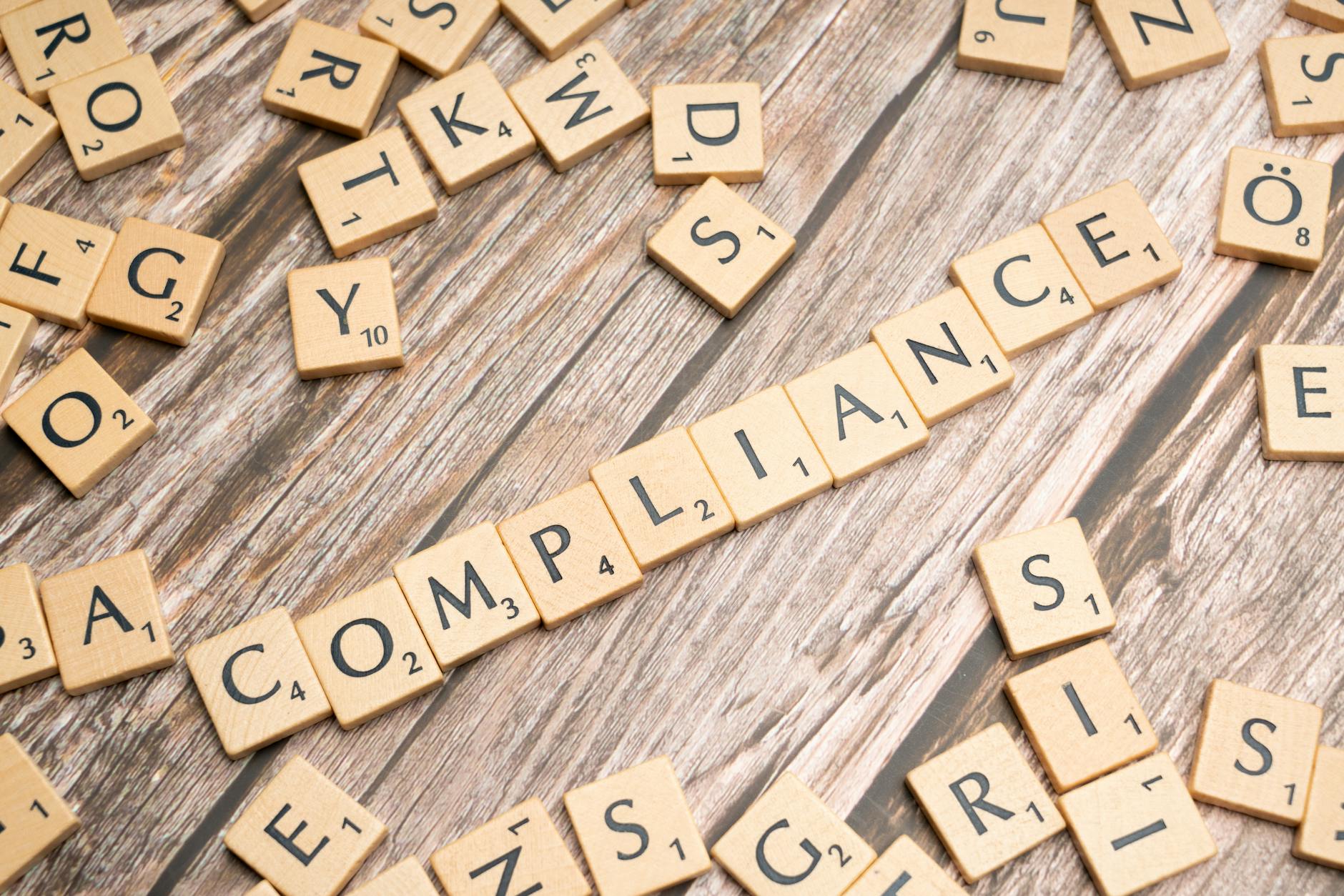 Drewniane kafelki z napisem compliance na rustykalnym tle