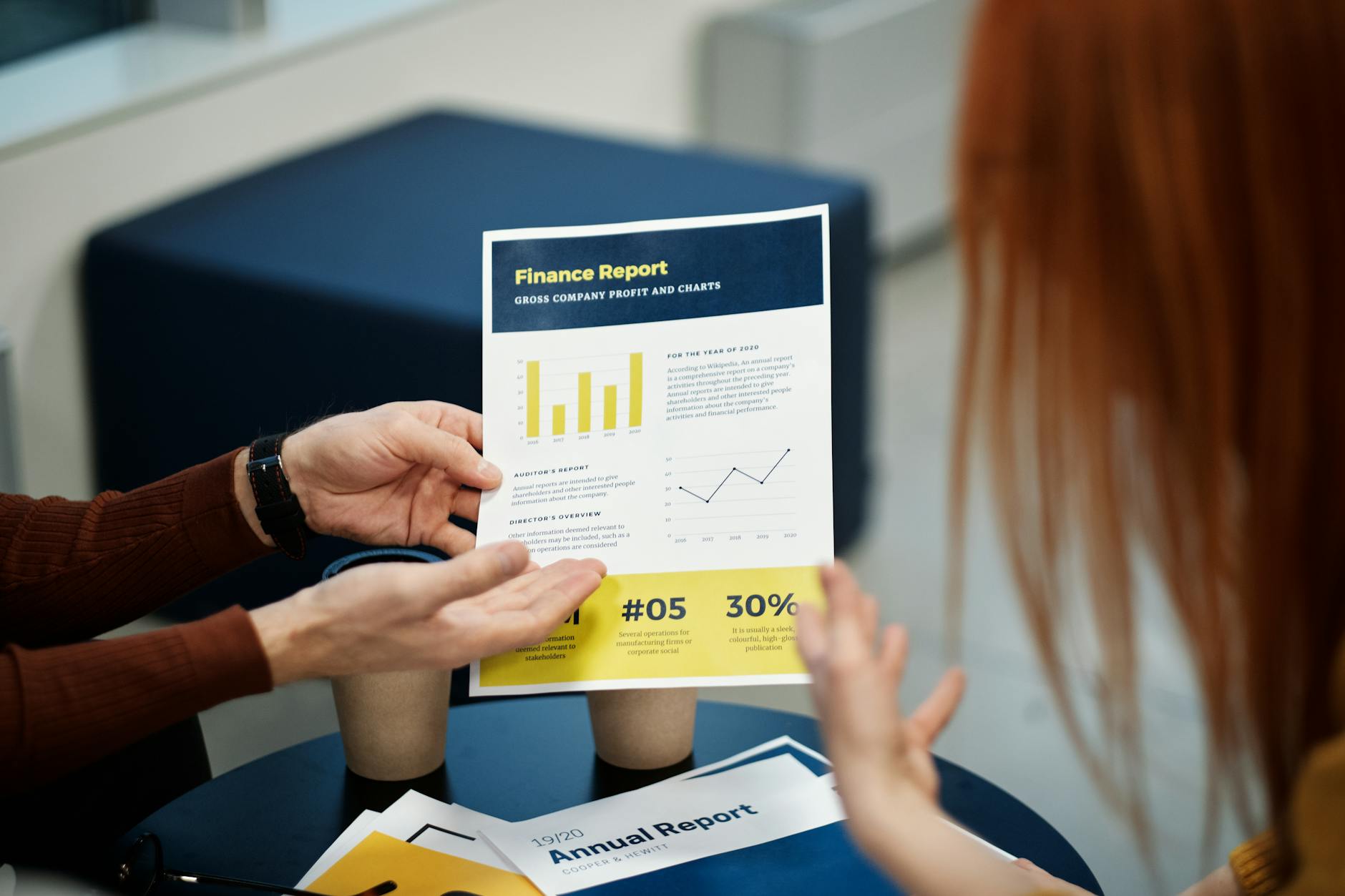 Dwie osoby analizują wykres ze sprawozdaniem finansowym w biurze