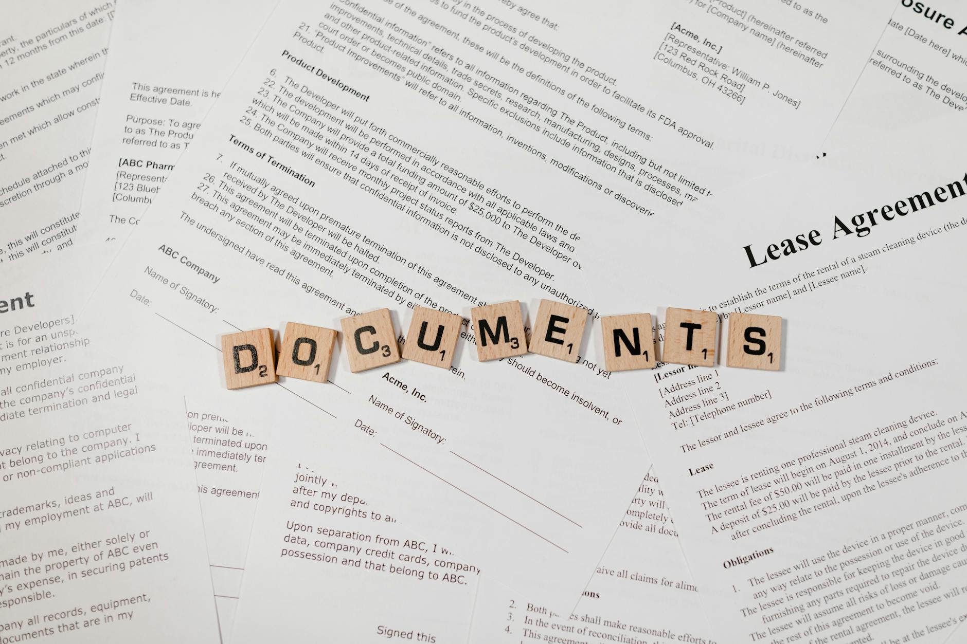 Kafelki z napisem DOCUMENTS na tle rozłożonych umów i kontraktów