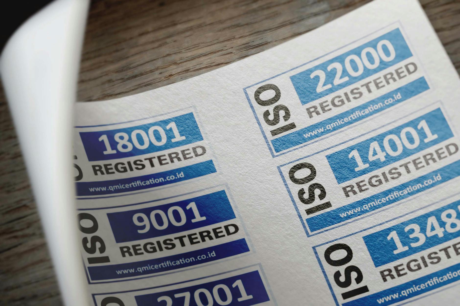 Naklejki z certyfikacją ISO i numerami rejestracyjnymi na dokumentach