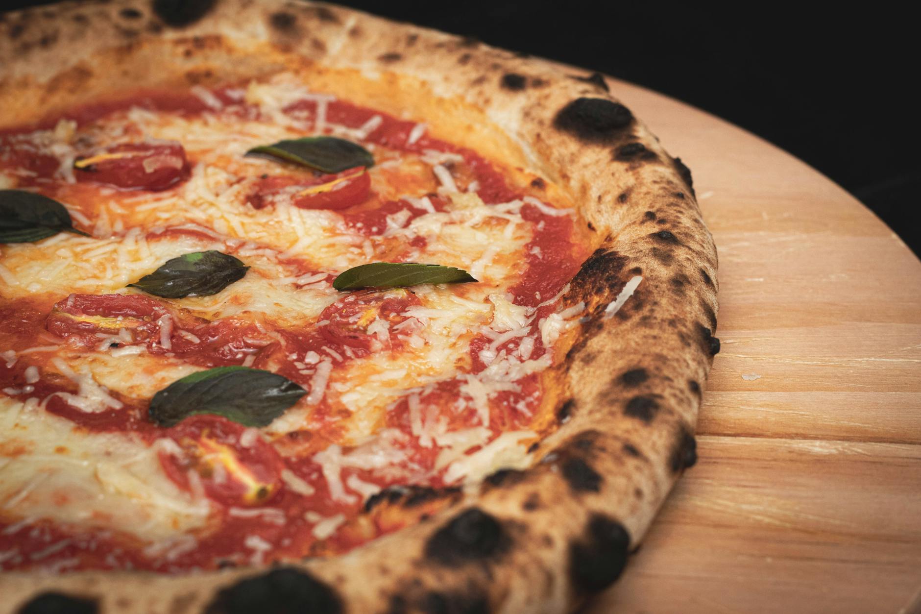 Pizza Margherita z serem i bazylią na drewnianej desce