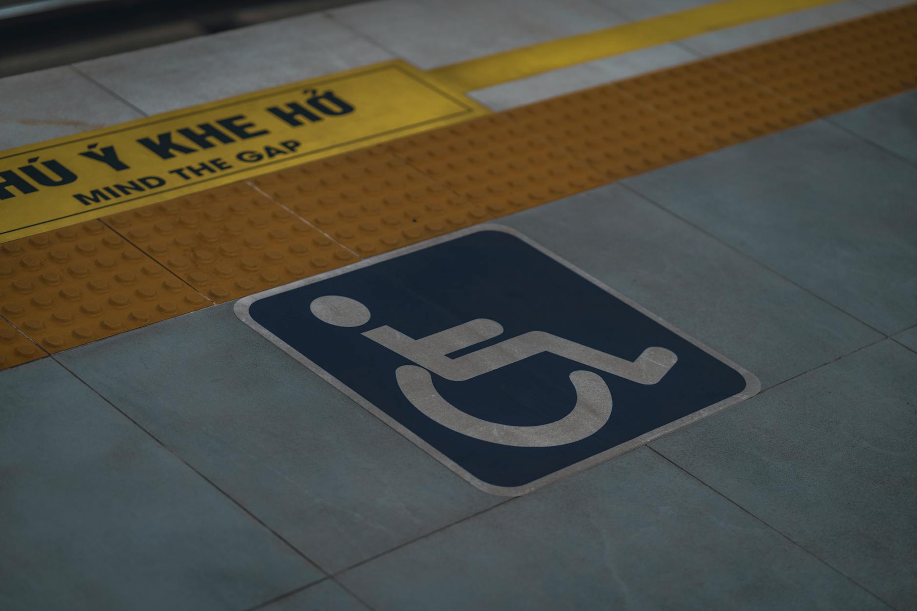 Symbol wózka inwalidzkiego i napis Mind the Gap na peronie stacji