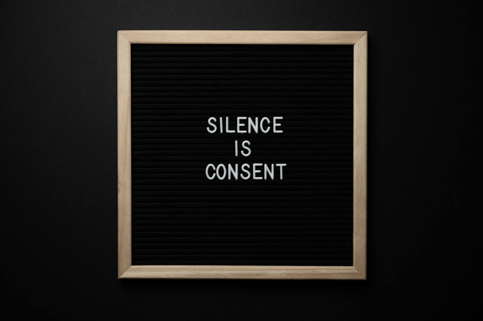 Tablica z napisem Silence is consent na czarnym tle