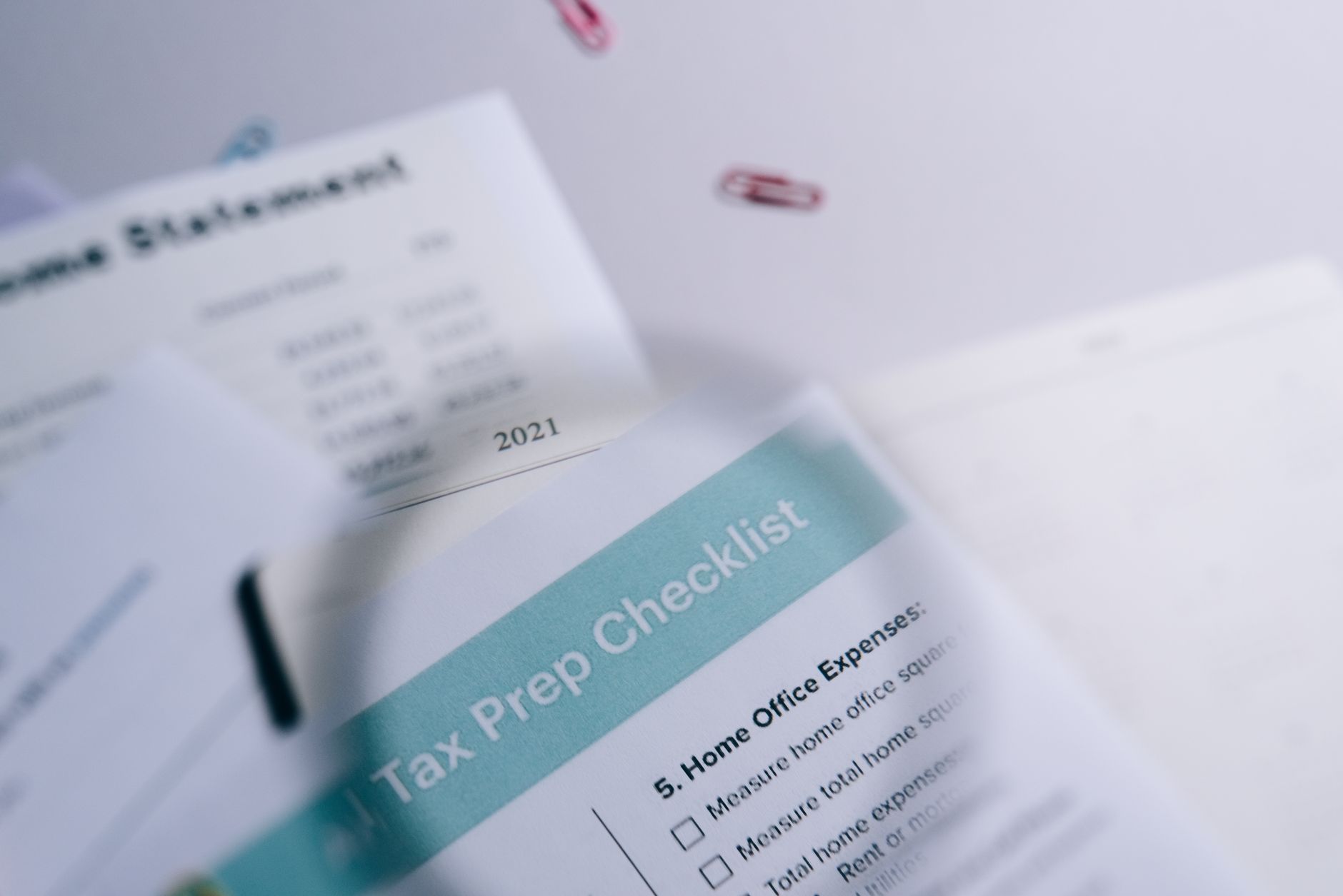 Zbliżenie na checklistę i zestawienie przychodów spięte spinaczami